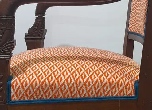 Tissu d'ameublement Origami colori orangé, apposé sur un fauteuil retapissé. Collection Lelievre.