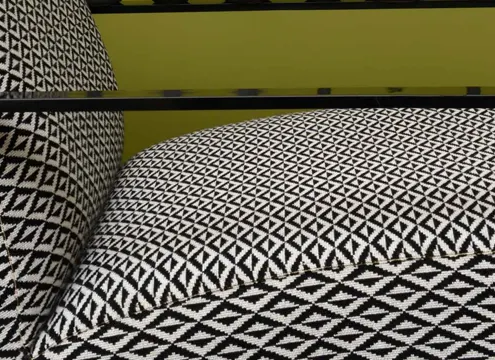 Gros plan sur une banquette recouverte par le tissu d'ameublement Origami, coloris noir. Lelievre.